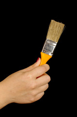 Woman hand holding paintbrush isolated on the black background