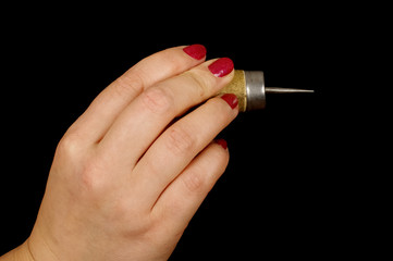 Female hand holding awl isolated on the black