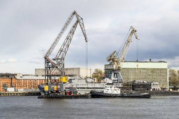 Fototapeta na wymiar Floating cranes and tugs on the river Neva in Saint Petersburg