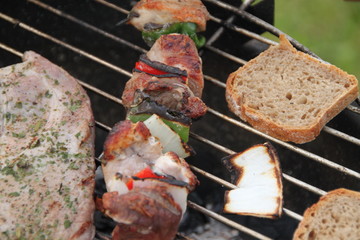 Schaschlikspieße, Grillfleisch und Brot auf dem Grill