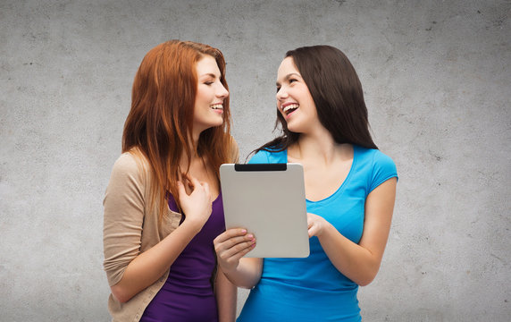 two smiling teenagers with tablet pc computer