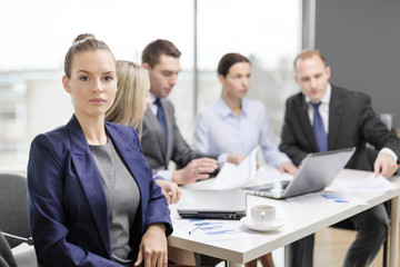 businesswoman in office with team on the back