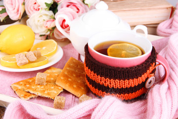 Cup of tea with lemon in scarf close up