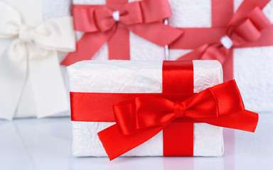Beautiful gifts with red ribbons, close up