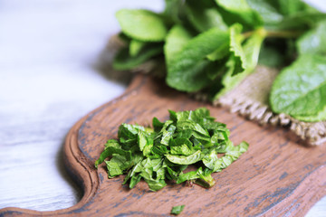 Mint on cutting board, on color wooden background