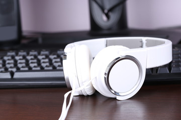 Obraz na płótnie Canvas Headphone and keyboard close-up on wooden desk background