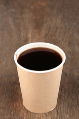 Paper cup of coffee on wooden table