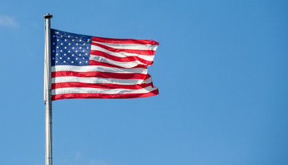 American flag waving with clear blue sky