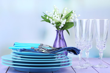 Clean dishes on wooden table on light background
