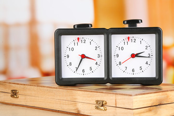 Chess clock and board on light background