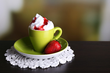 Cup of coffee with cream and strawberry sauce