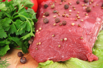 Raw beef meat with spices and vegetables close up