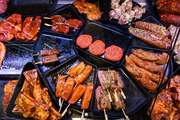 Marinaded meat for grilling in a counter display in a supermarke