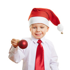 Kind mit Weihnachtsmütze und Christbaumkugel