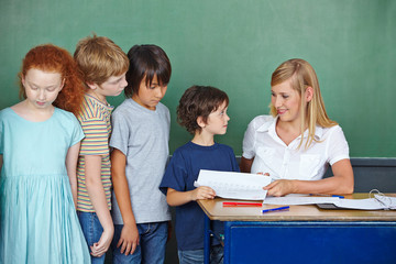 Lehrerin gibt Kindern Test zurück