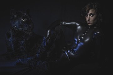 Sensual brunette woman dressed in latex with huge black panther