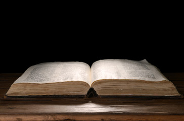 Old book on table on black background
