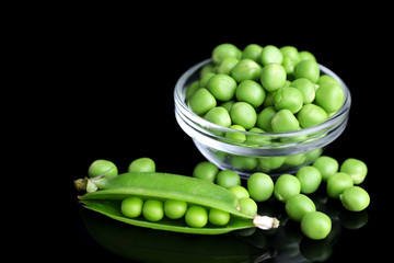 Fresh green peas in bowl isolated on black background