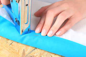 Fastening fabric and board using construction stapler