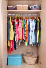 Colorful clothes hanging in wardrobe