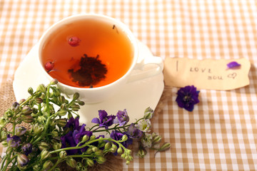 Cup of fresh herbal tea on table