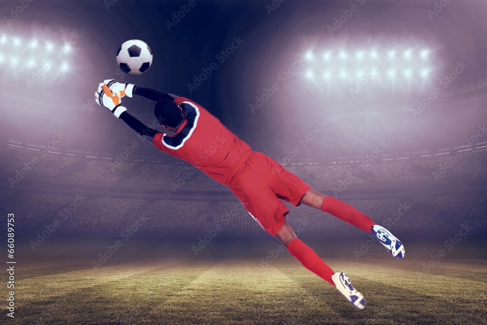 Fototapete composite image of goalkeeper in red making a save