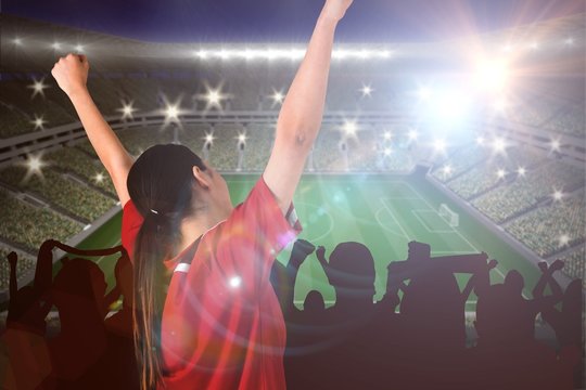 Composite image of excited asian football fan cheering
