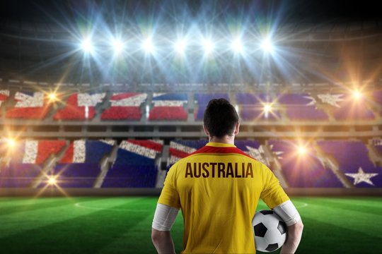 Composite image of australia football player holding ball