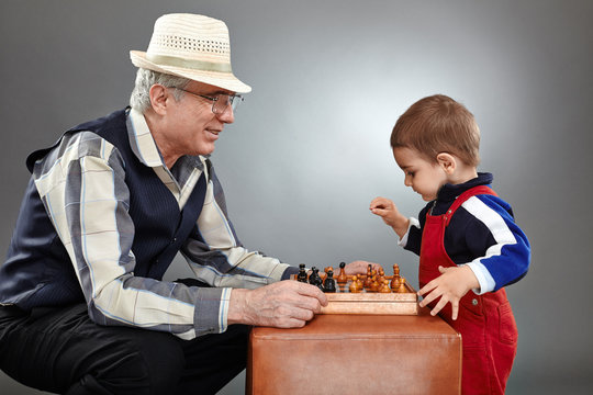 Grandfather And Grandson Playing Chess