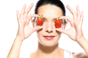 Schöne Frau hält Erdbeeren an ihre Augen