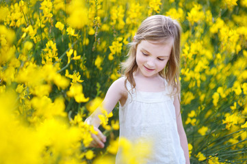 Naklejka na ściany i meble Adorable girl in blooming yellow flowers
