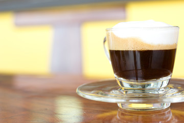 Hot  espresso with milk and foam in cup.