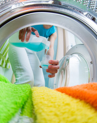 householder woman using conditioner for  washing machine