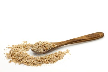 Löffel aus Olivenholz mit Dinkelschrot isoliert auf weißem Hintergrund