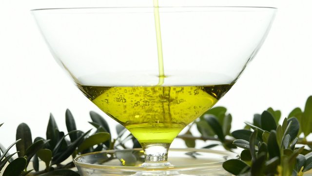 Oliven&ouml;l l&auml;uft in ein Glas