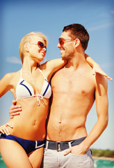 happy couple in sunglasses on the beach