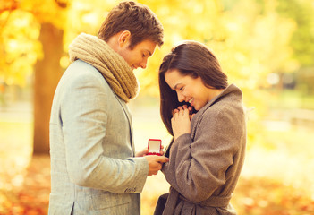 man proposing to a woman in the autumn park