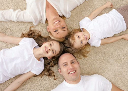 parents and two girls lying on floor at home