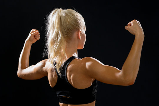 sporty woman from the back flexing her biceps