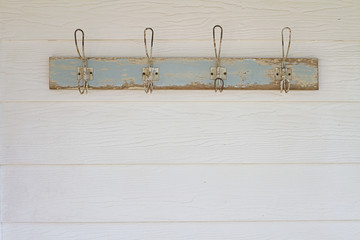 Rustic coat hooks background on white weatherboard house