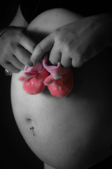 petits chaussons rose sur ventre de femme enceinte
