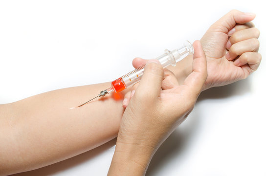 Hand with heroin syringe. Close-up photo.