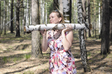 The young woman with a log in the wood.