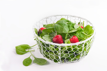 Baby spinach and strawberries isolated on white background