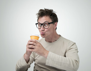 Funny man in glasses drink through a straw