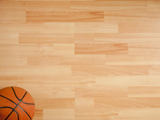 Obraz premium An official orange ball on a hardwood basketball court