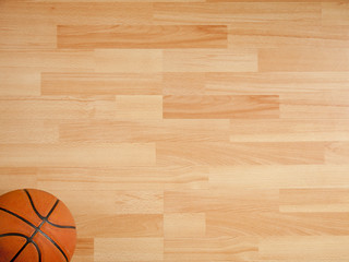 An official orange ball on a hardwood basketball court