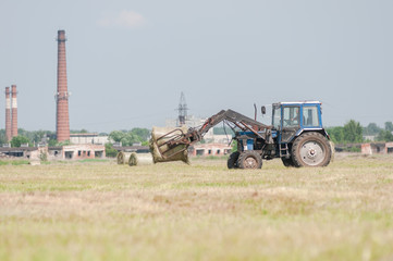 Fototapeta premium Mechanized harvesting of grass on the flood-plain meadow