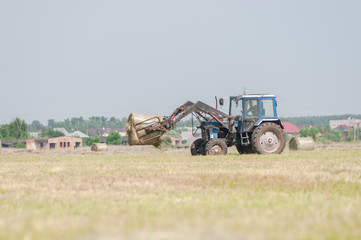 Fototapeta premium Mechanized harvesting of grass on the flood-plain meadow