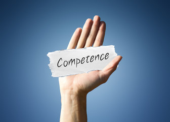 Man holding a scrap of paper with - Competence